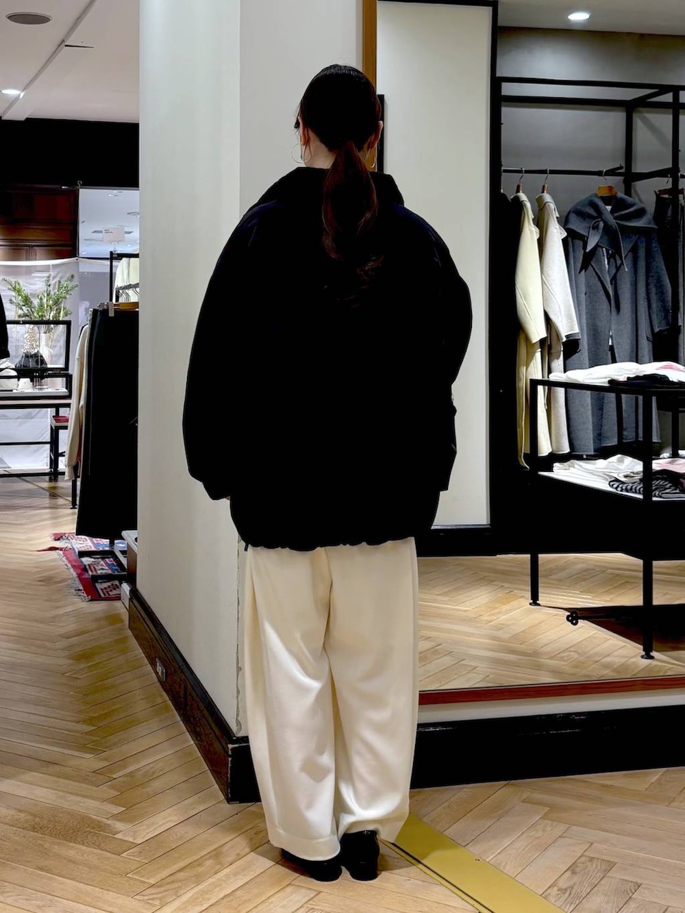 ホワイト系のスラックス、ブラック系のローファー、ブラック系のブルゾンを着用したレディースの冬コーディネートの4枚目の写真