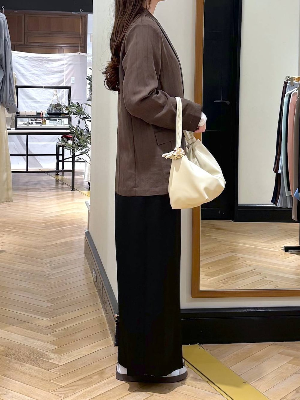 ブラウン系のテーラードジャケット、ベージュ系のショルダーバッグ、ホワイト系のTシャツ/カットソーを着用したレディースの春コーディネートの2枚目の写真