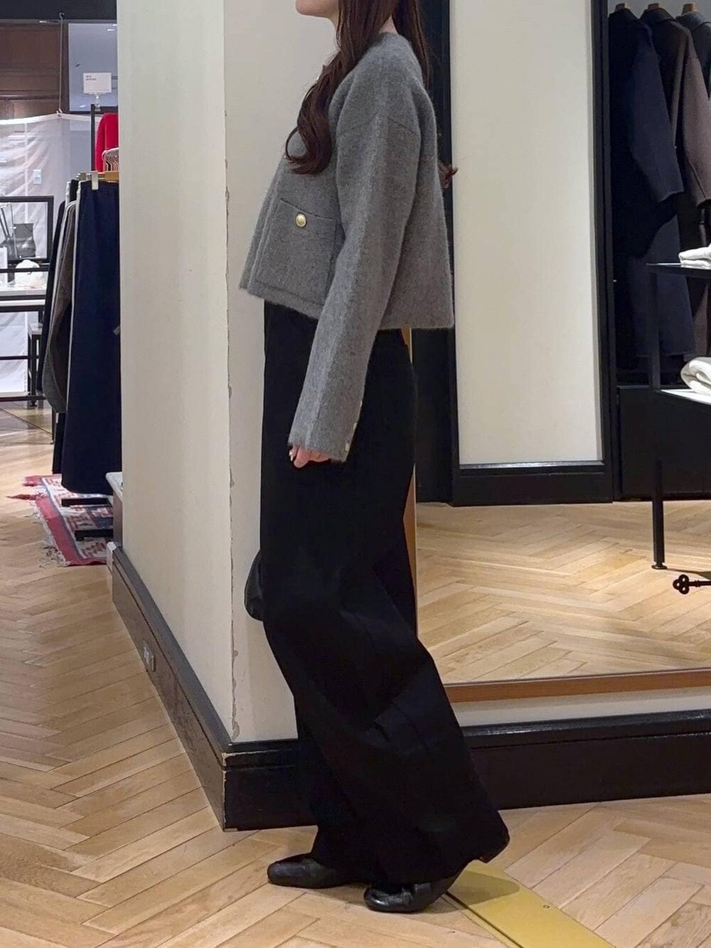 ブラック系のデニムパンツ、ブラック系のローファー、ブラック系のショルダーバッグを着用したレディースの秋コーディネートの2枚目の写真