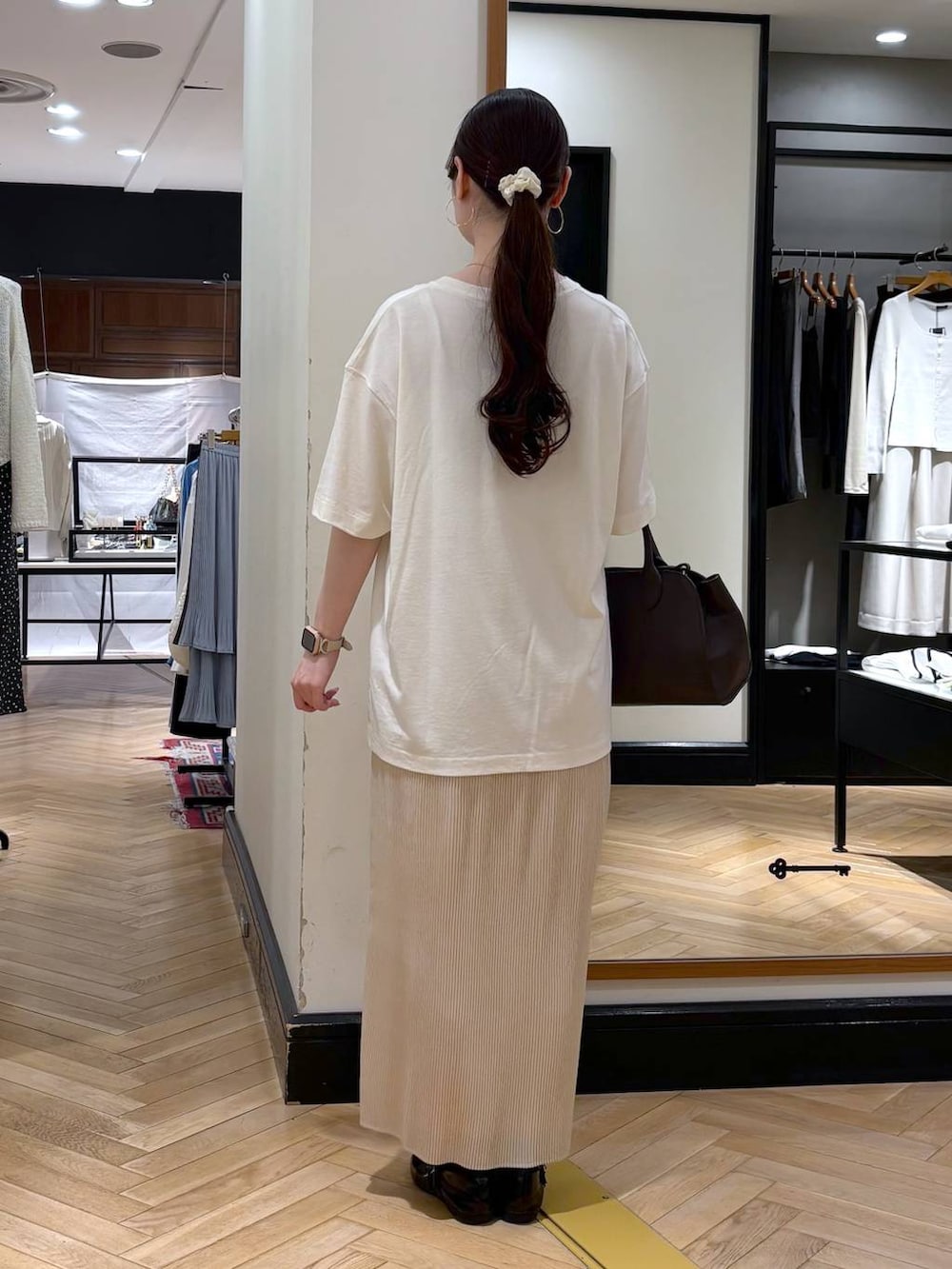 ホワイト系のスカート、ブラック系のショルダーバッグ、ブルー系のTシャツ/カットソーを着用したレディースの春コーディネートの4枚目の写真