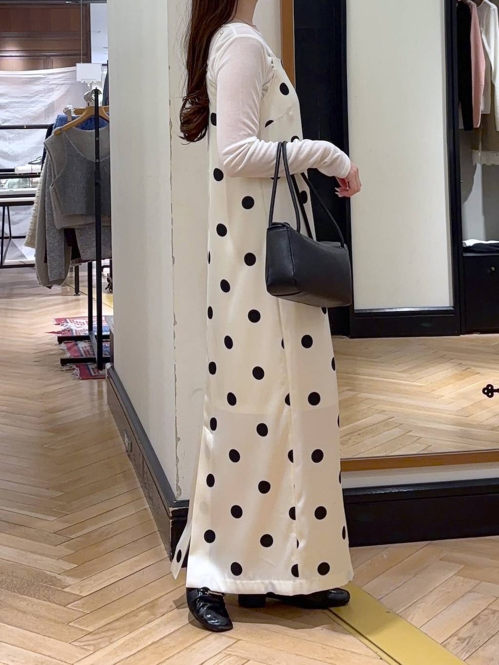 ブラック系のローファー、ホワイト系のTシャツ/カットソー、ブラック系のショルダーバッグを着用したレディースの冬コーディネートの2枚目の写真