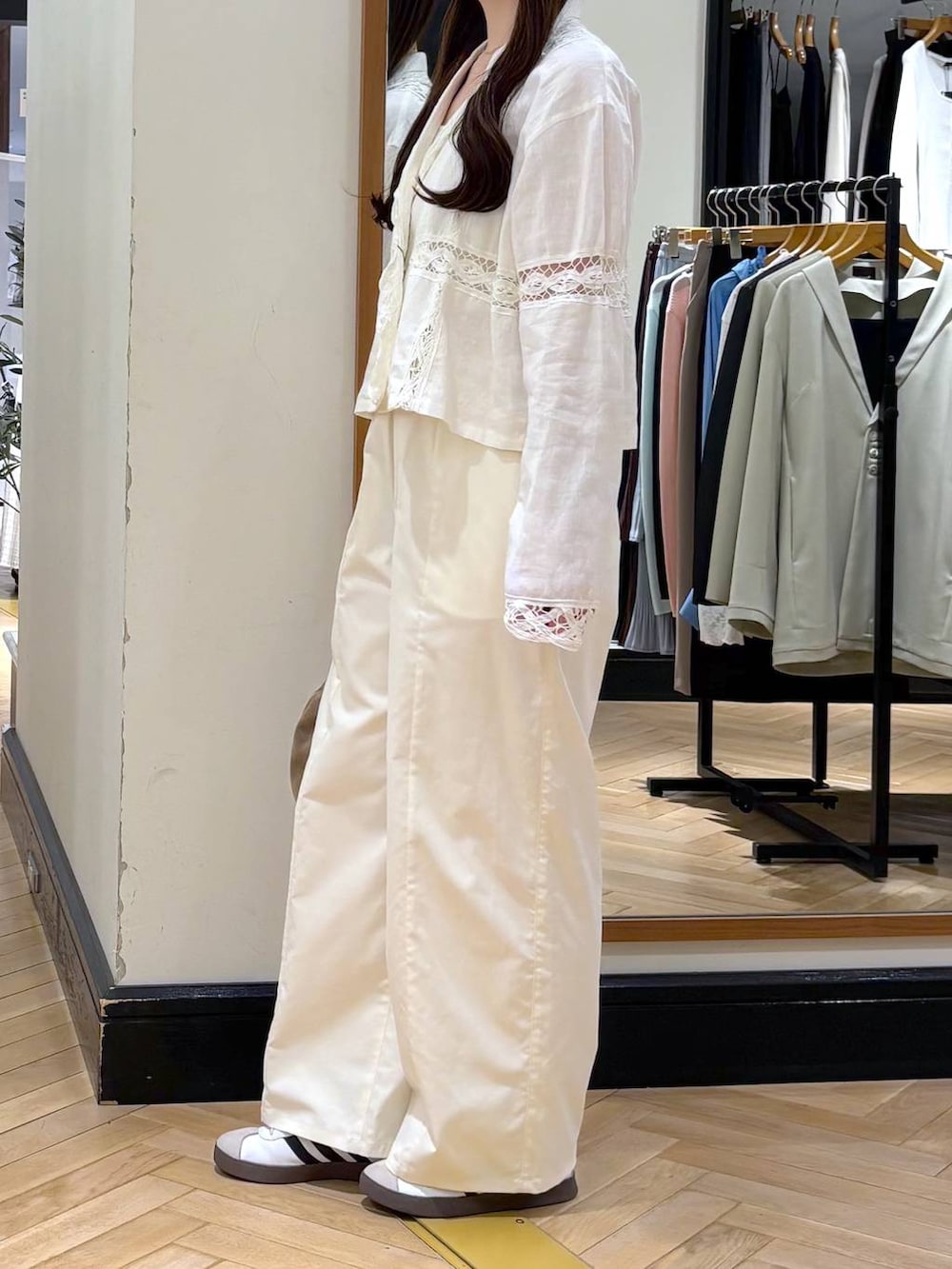 ベージュ系のショルダーバッグ、ホワイト系のスラックス、ホワイト系のシャツ/ブラウスを着用したレディースの春コーディネートの3枚目の写真