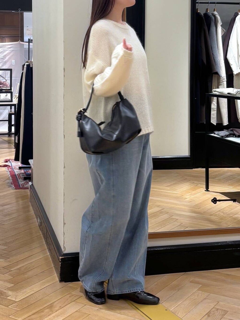 ブルー系のデニムパンツ、ブラック系のローファー、ホワイト系のニット/セーターを着用したレディースの秋コーディネートの4枚目の写真