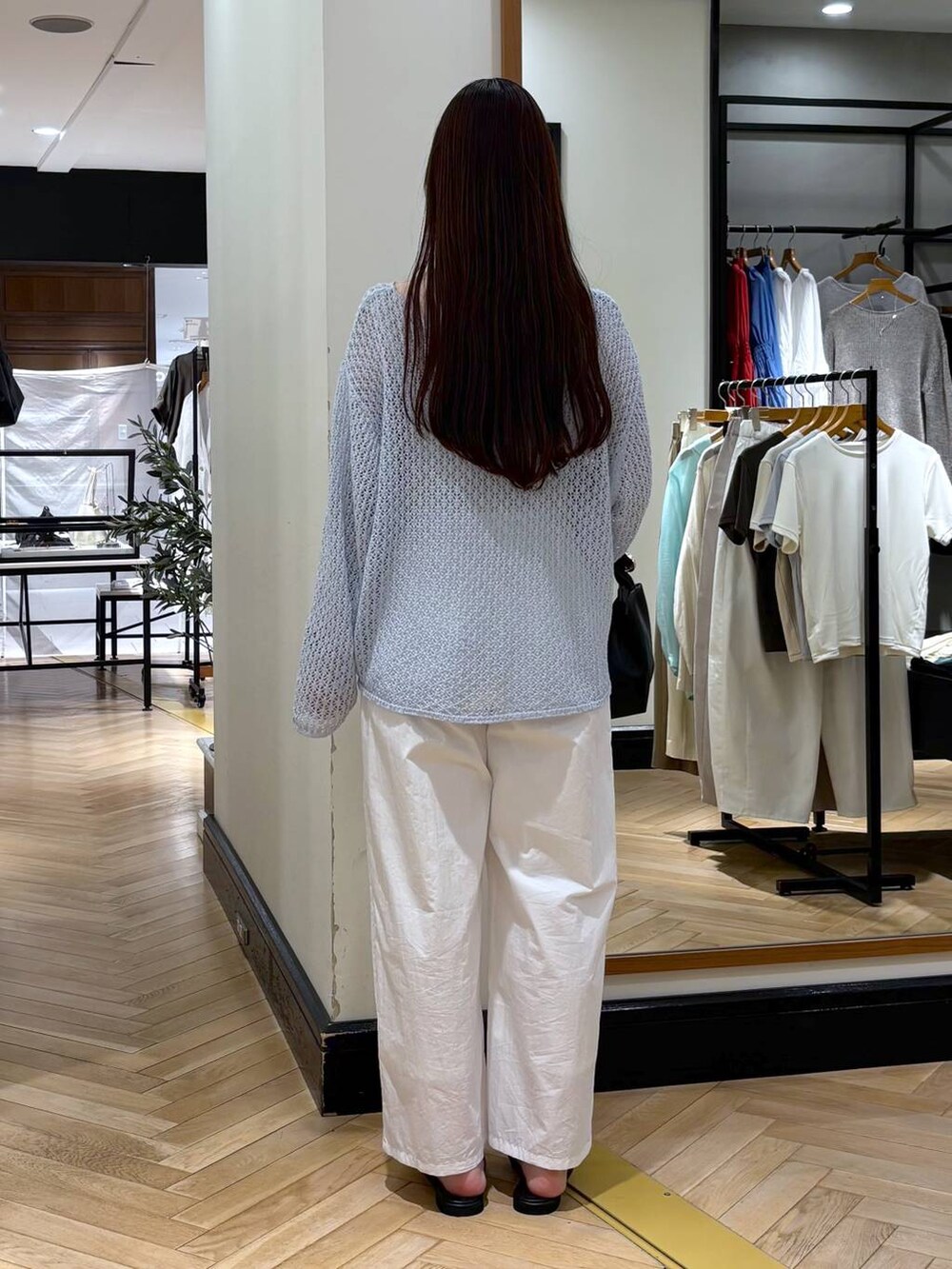 ブラック系のショルダーバッグ、ホワイト系のその他パンツ、ブルー系のニット/セーターを着用したレディースの春コーディネートの4枚目の写真