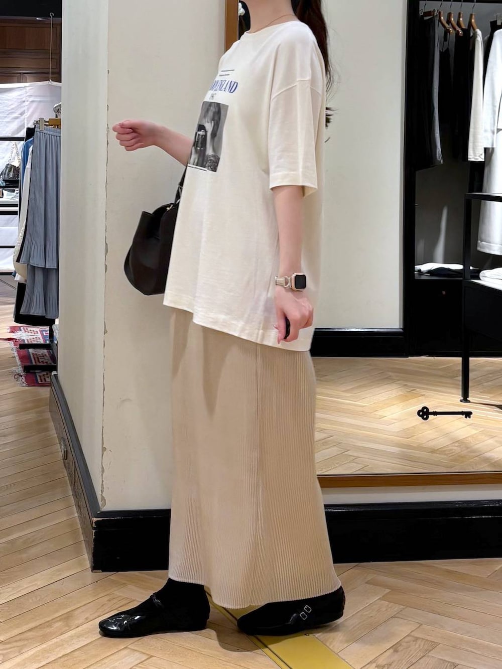 ホワイト系のスカート、ブラック系のショルダーバッグ、ブルー系のTシャツ/カットソーを着用したレディースの春コーディネートの3枚目の写真