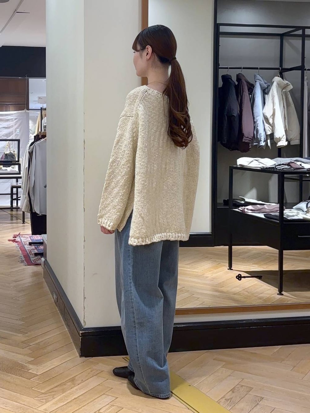 ブルー系のデニムパンツ、ベージュ系のノーカラーコート、ブラック系のショルダーバッグを着用したレディースの秋コーディネートの8枚目の写真