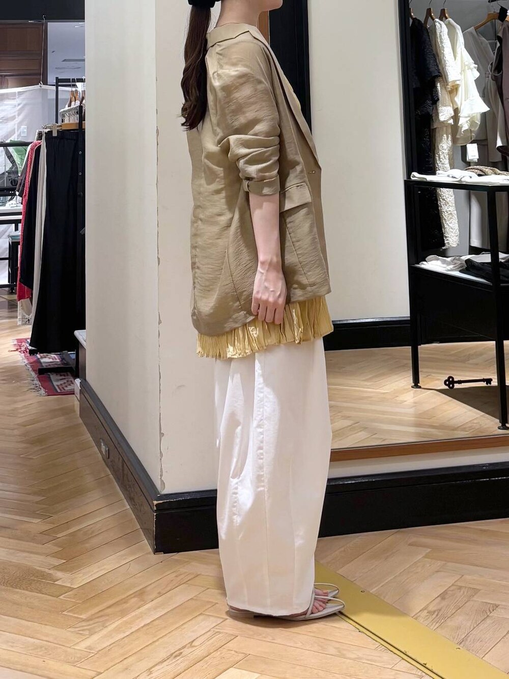 ホワイト系のサンダル、ベージュ系のテーラードジャケット、イエロー系のシャツ/ブラウスを着用したレディースの夏コーディネートの2枚目の写真