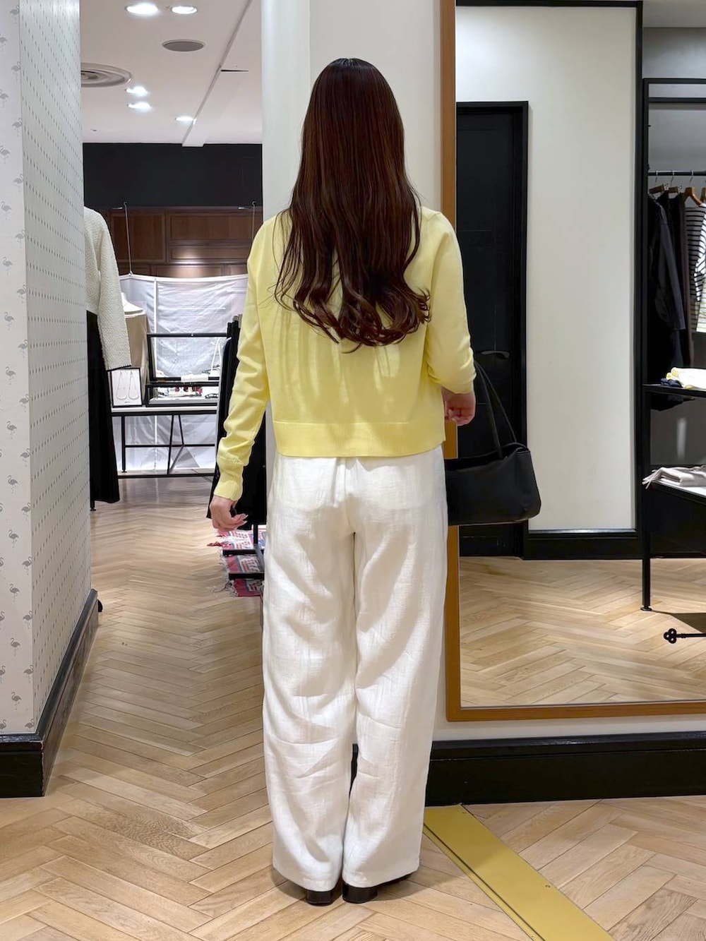 ブラック系のローファー、ブラック系のショルダーバッグ、イエロー系のカーディガン/ボレロを着用したレディースの冬コーディネートの6枚目の写真