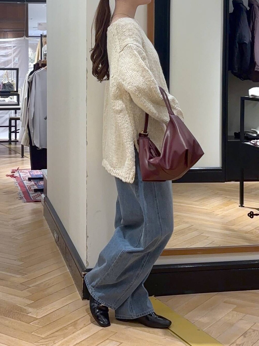 ブルー系のデニムパンツ、ベージュ系のノーカラーコート、ブラック系のショルダーバッグを着用したレディースの秋コーディネートの6枚目の写真
