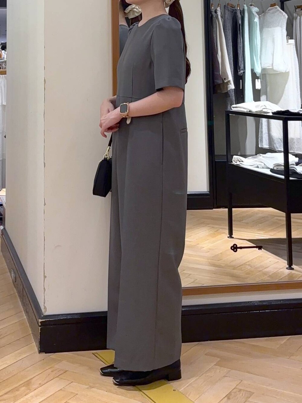 ブラック系のパンプス、ブラック系のショルダーバッグ、グレー系のつなぎ/オールインワンを着用したレディースの秋コーディネートの5枚目の写真