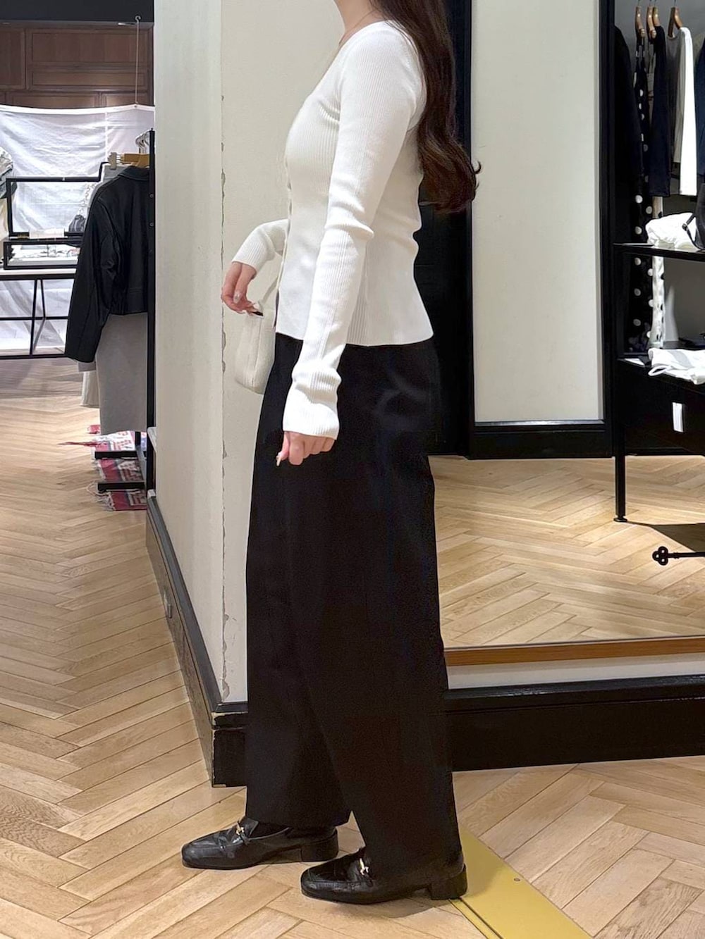 ブラック系のローファー、ホワイト系のカーディガン/ボレロ、ホワイト系のショルダーバッグを着用したレディースの春コーディネートの3枚目の写真