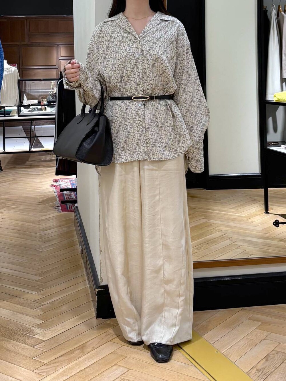 ブラック系のローファー、ホワイト系のその他パンツ、ブラック系のショルダーバッグを着用したレディースの春コーディネートの2枚目の写真