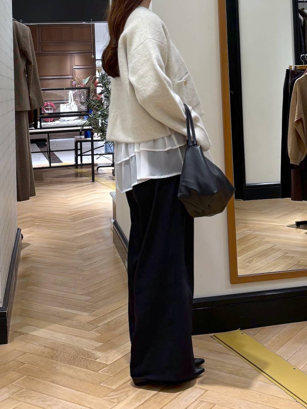 ブラック系のパンプス、ベージュ系のTシャツ/カットソー、ブラック系のスラックスを着用したレディースの秋コーディネートの2枚目の写真