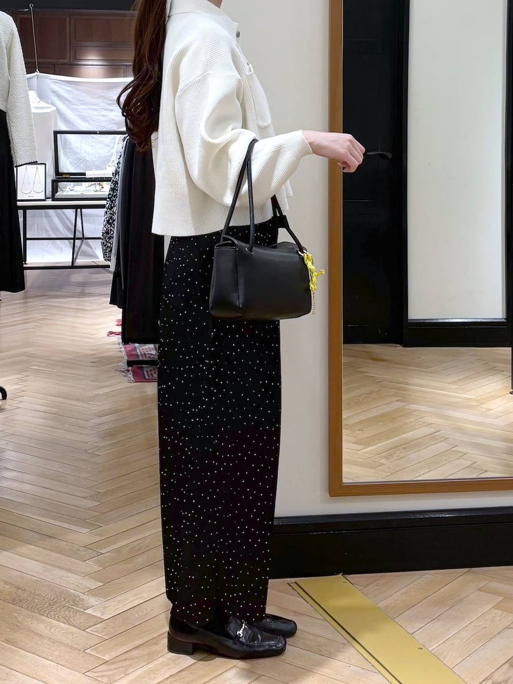 ブラック系のローファー、その他のスカート、ブラック系のショルダーバッグを着用したレディースの冬コーディネートの2枚目の写真