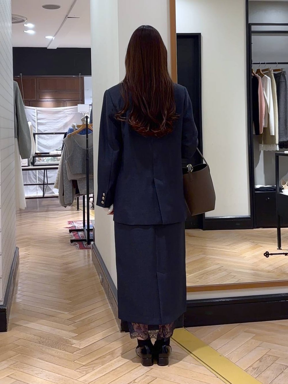 ブラック系のローファー、ブルー系のスカート、ブルー系のテーラードジャケットを着用したレディースの冬コーディネートの4枚目の写真