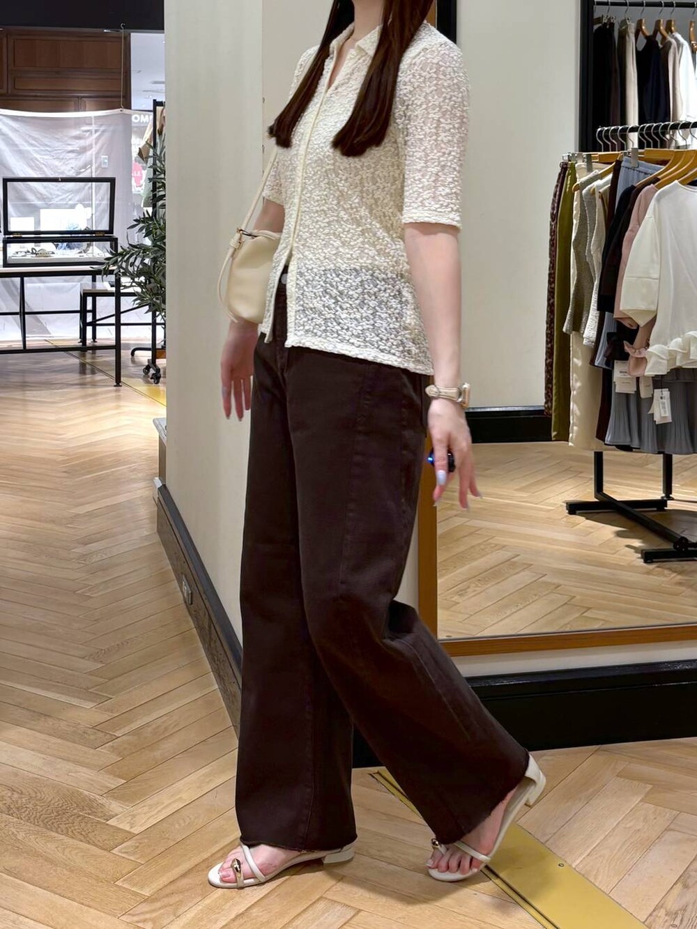 ホワイト系のショルダーバッグ、ホワイト系のTシャツ/カットソー、ホワイト系のサンダルを着用したレディースの夏コーディネートの3枚目の写真