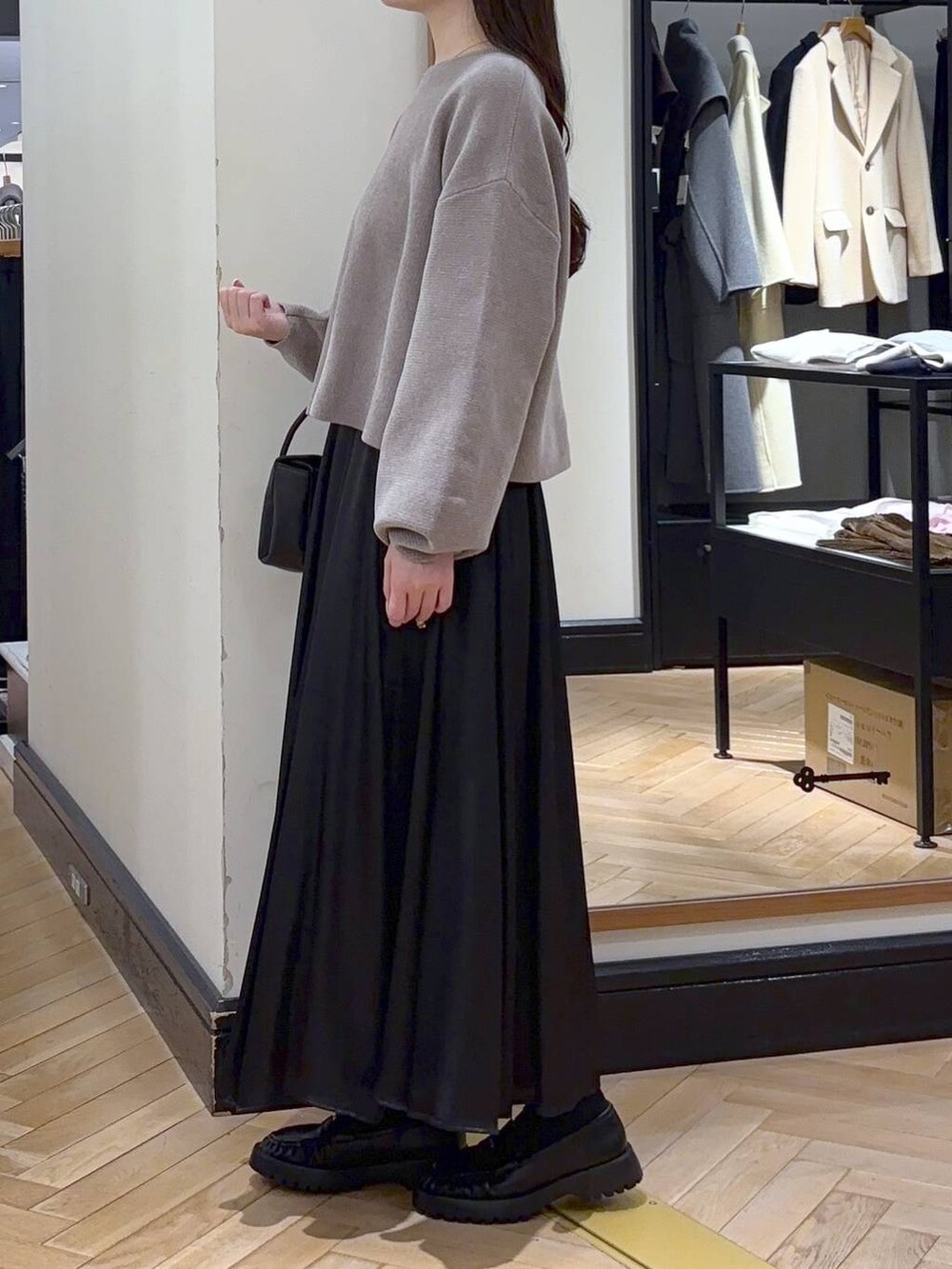 ベージュ系のニット/セーター、ブラック系のローファー、ブラック系のスカートを着用したレディースの冬コーディネートの3枚目の写真