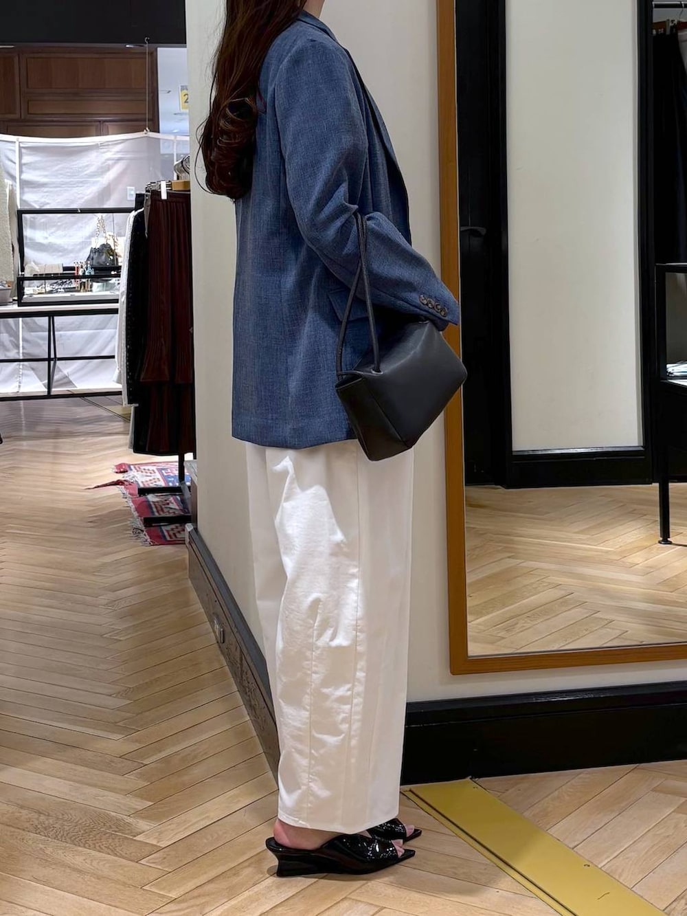 ブルー系のノーカラージャケット、ブラック系のショルダーバッグ、ブラック系のサンダルを着用したレディースの春コーディネートの3枚目の写真