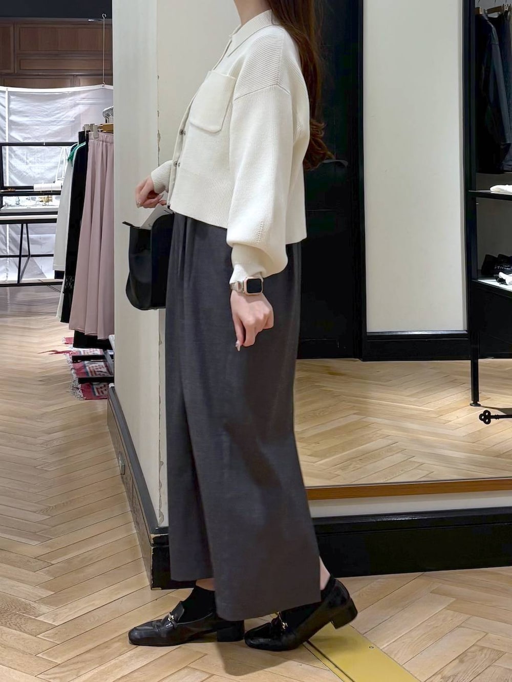 ブラック系のローファー、ブラック系のショルダーバッグ、グレー系のワンピースを着用したレディースの春コーディネートの2枚目の写真