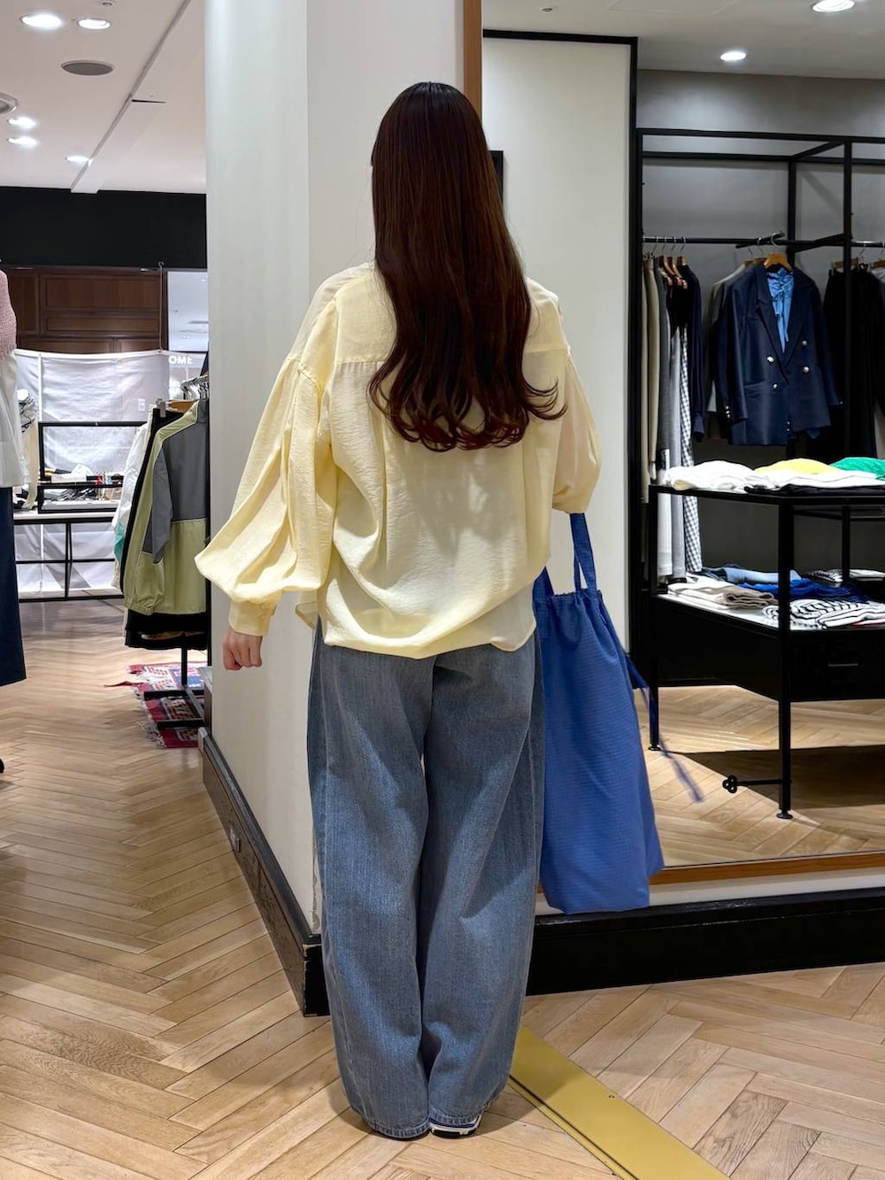 ブルー系のデニムパンツ、シルバー系のスニーカー、イエロー系のシャツ/ブラウスを着用したレディースの春コーディネートの4枚目の写真