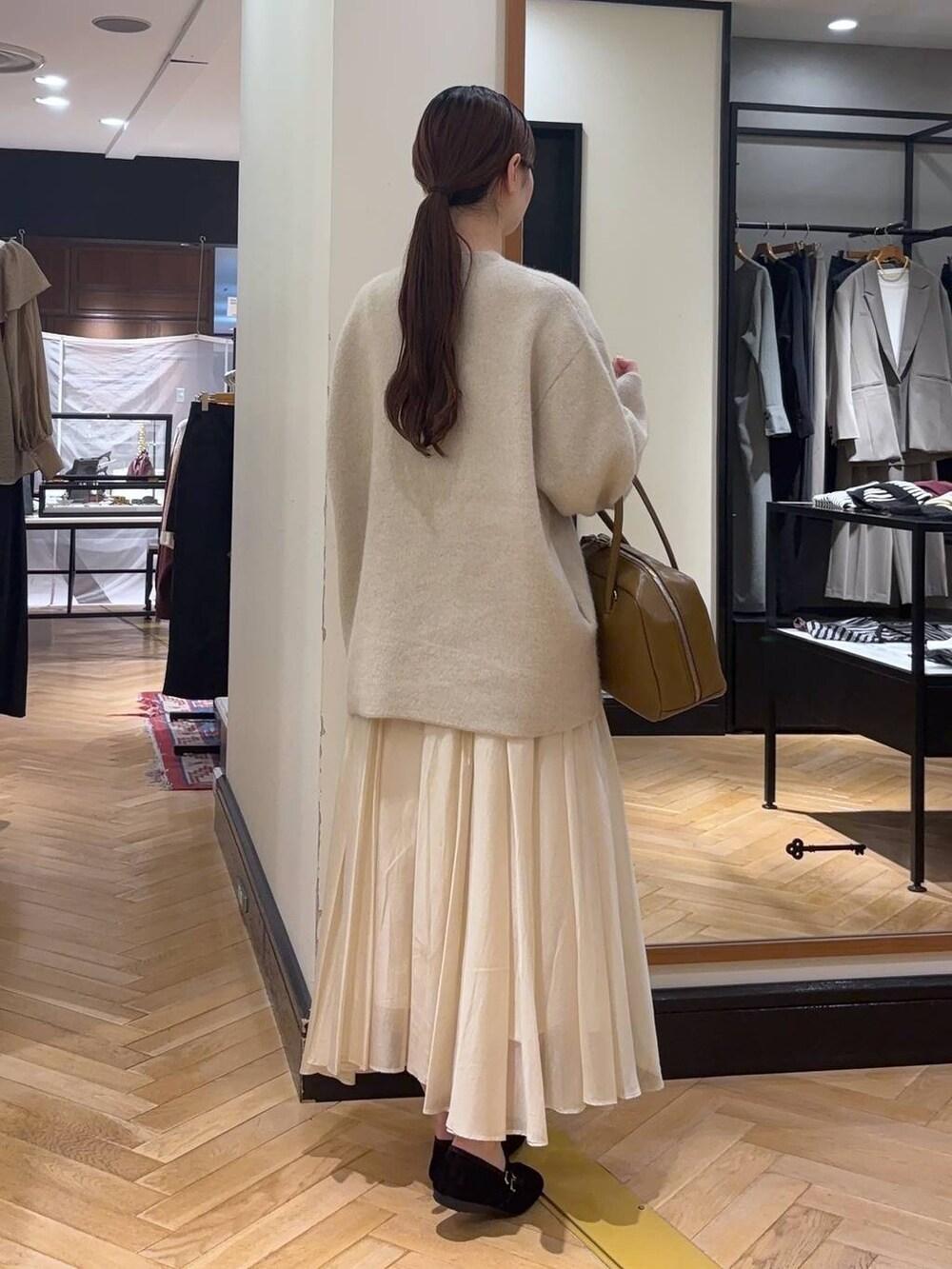 ホワイト系のカーディガン/ボレロ、ブラウン系のボストンバッグ、ブラック系のバレエシューズを着用したレディースの秋コーディネートの4枚目の写真