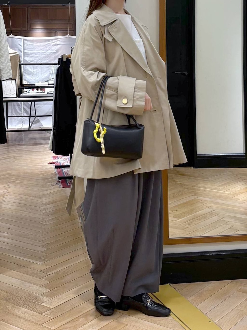 グレー系のスラックス、ブラック系のローファー、ホワイト系のシャツ/ブラウスを着用したレディースの冬コーディネートの2枚目の写真