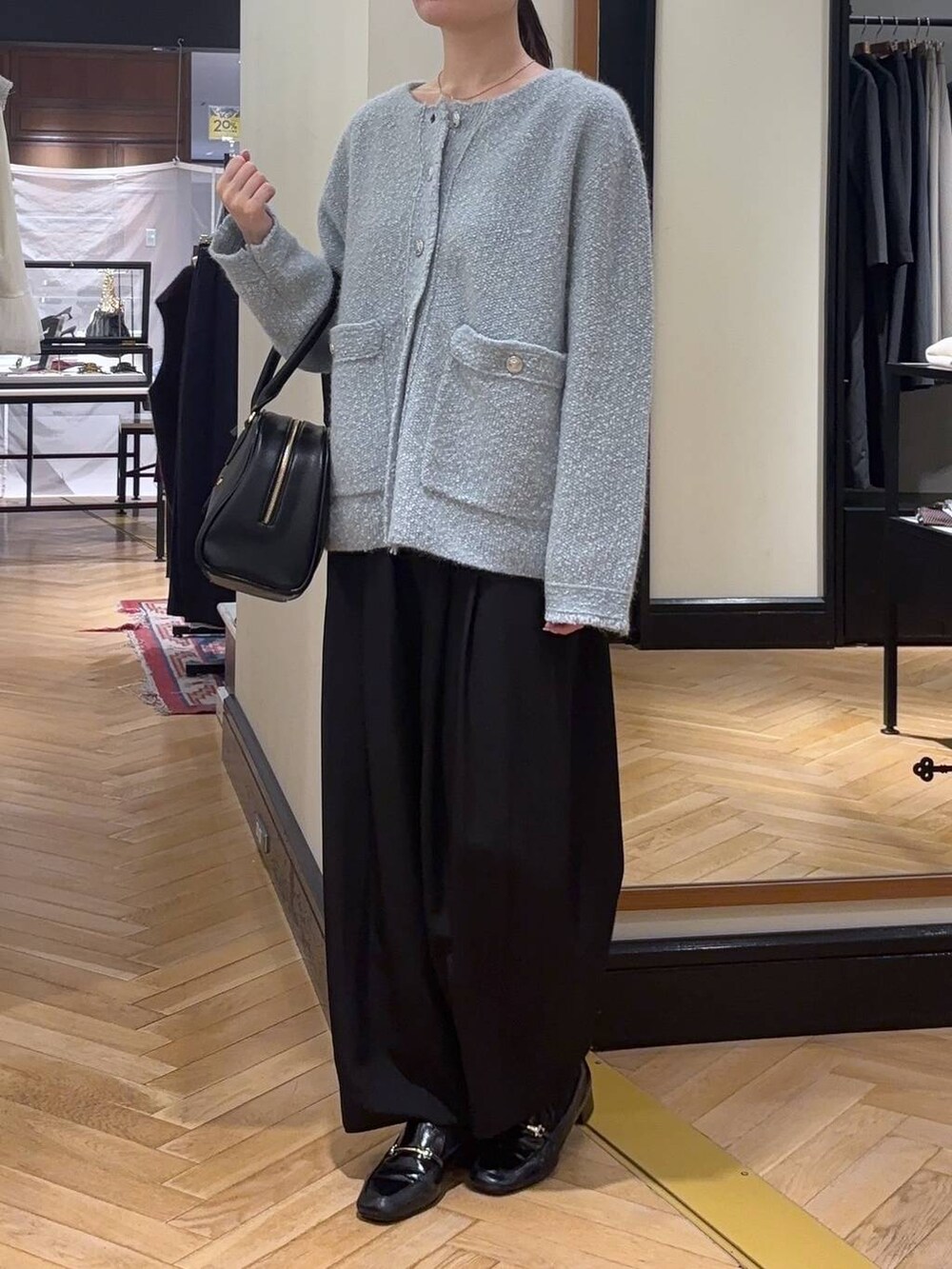 ブラック系のローファー、ブルー系のカーディガン/ボレロ、ブラック系のスラックスを着用したレディースの秋コーディネートの4枚目の写真