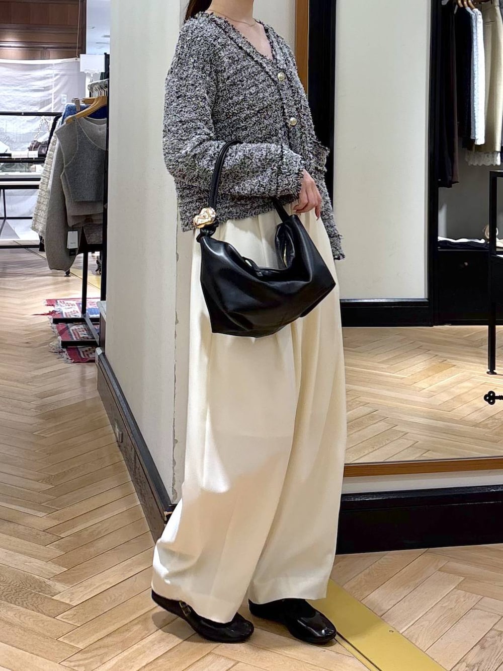 ホワイト系のスラックス、ブラック系のショルダーバッグ、ブラック系のカーディガン/ボレロを着用したレディースの冬コーディネートの2枚目の写真