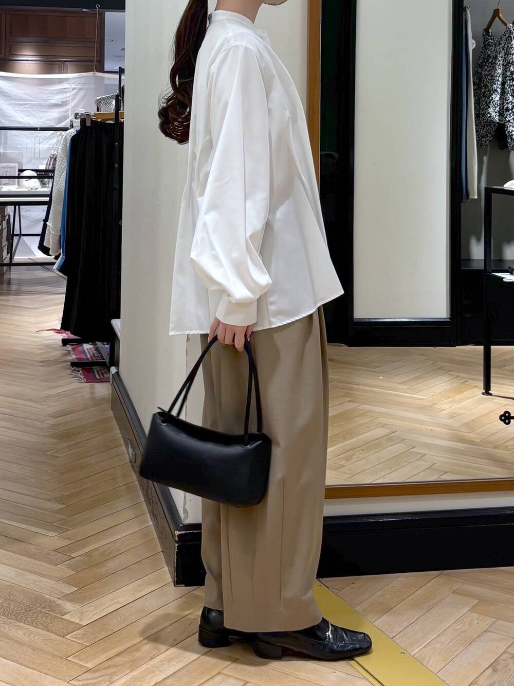 ベージュ系のスラックス、ブラック系のローファー、ホワイト系のTシャツ/カットソーを着用したレディースの冬コーディネートの5枚目の写真