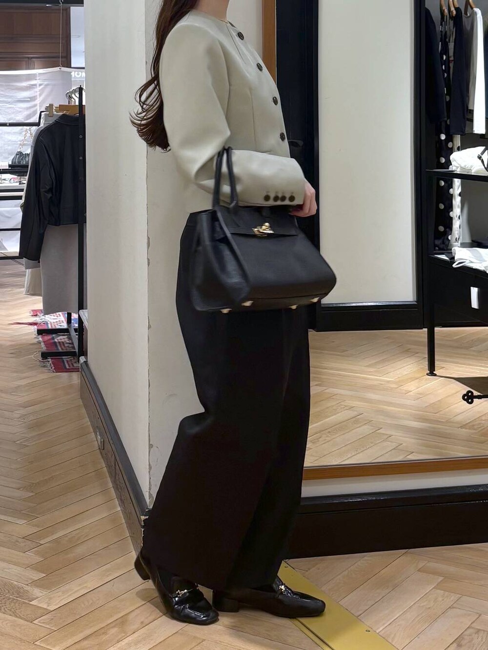 ブラック系のローファー、ブラック系のショルダーバッグ、ブラック系のチノパンツを着用したレディースの春コーディネートの2枚目の写真