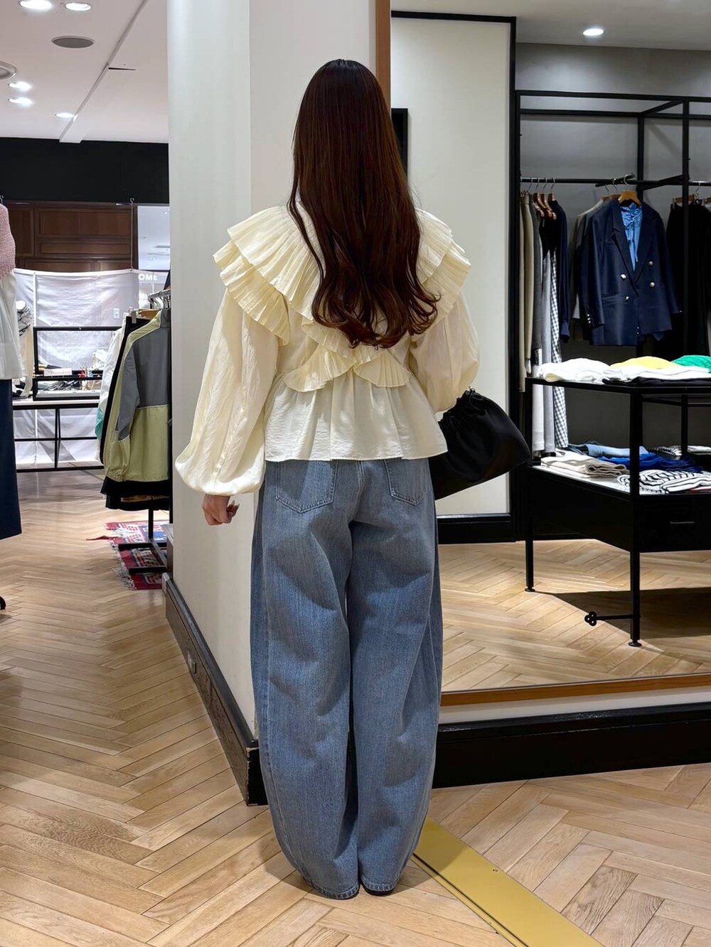 ブルー系のデニムパンツ、ブラック系のローファー、ブラック系のショルダーバッグを着用したレディースの春コーディネートの4枚目の写真