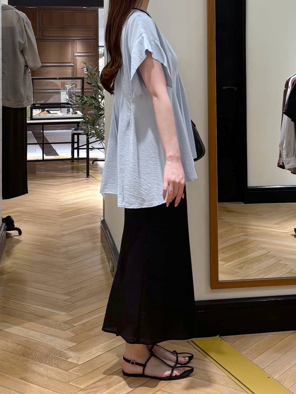 ブルー系のシャツ/ブラウス、ブラック系のスカート、ブラック系のショルダーバッグを着用したレディースの春コーディネートの2枚目の写真