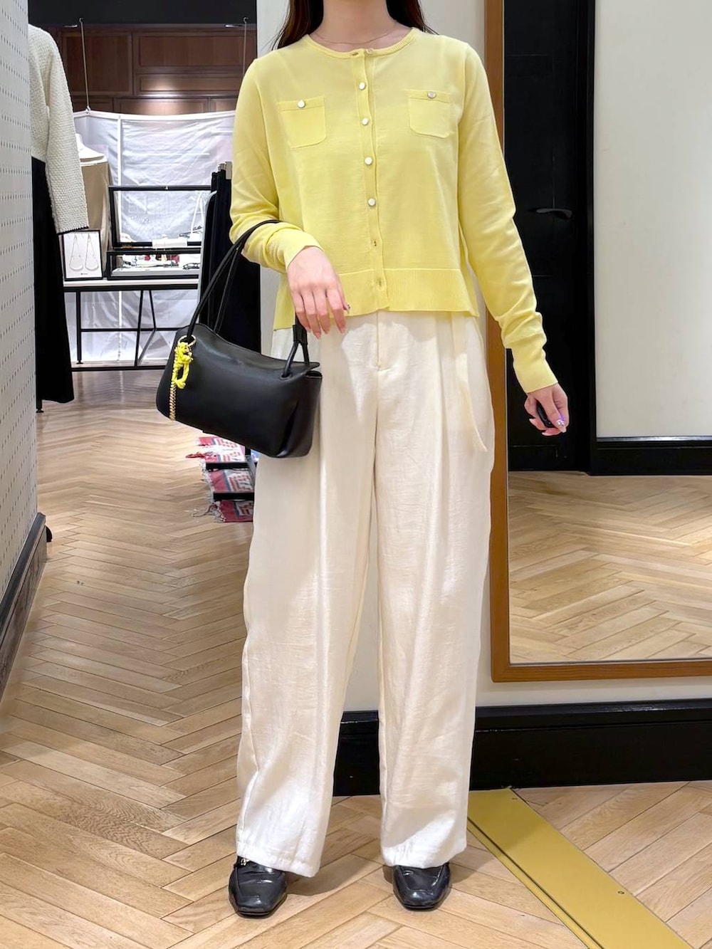 ブラック系のローファー、ブラック系のショルダーバッグ、イエロー系のカーディガン/ボレロを着用したレディースの冬コーディネートの2枚目の写真