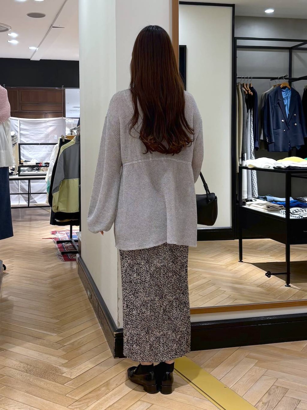 ブラック系のローファー、ベージュ系のスカート、グレー系のカーディガン/ボレロを着用したレディースの春コーディネートの5枚目の写真