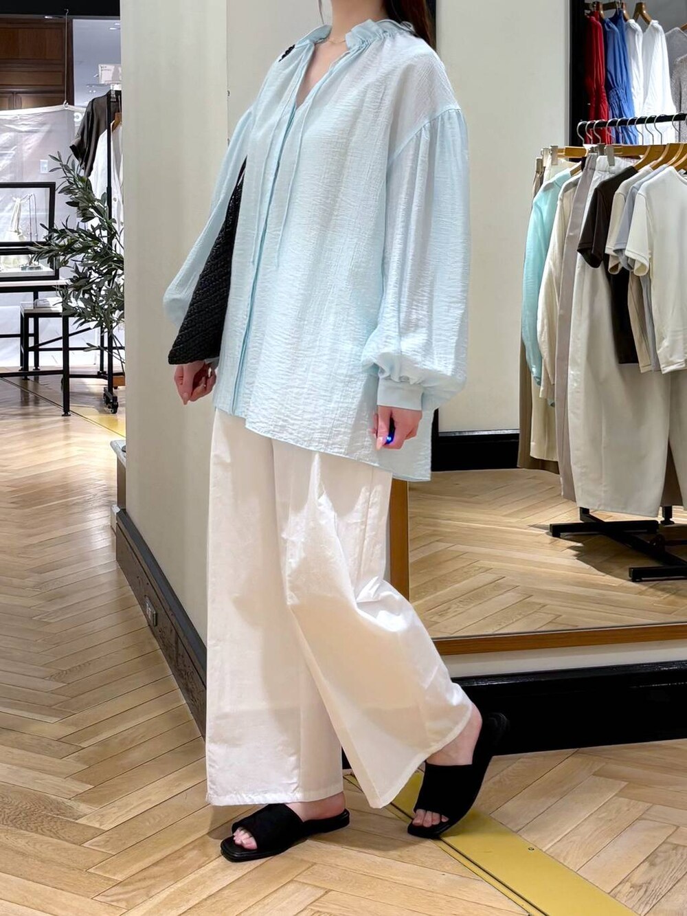 ホワイト系のその他パンツ、ブラック系のサンダル、ブルー系のシャツ/ブラウスを着用したレディースの春コーディネートの3枚目の写真