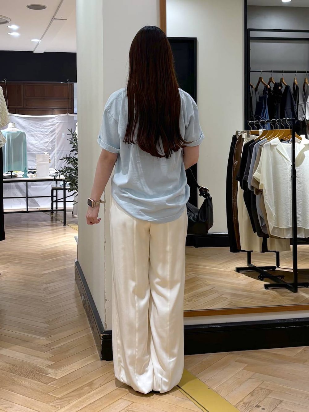 ブラック系のショルダーバッグ、ブルー系のTシャツ/カットソー、ブラック系のパンプスを着用したレディースの夏コーディネートの4枚目の写真