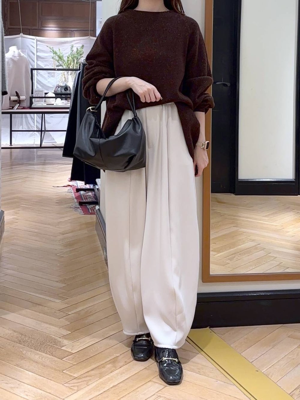 ブラック系のローファー、ブラウン系のニット/セーター、ブラック系のショルダーバッグを着用したレディースの冬コーディネートの2枚目の写真