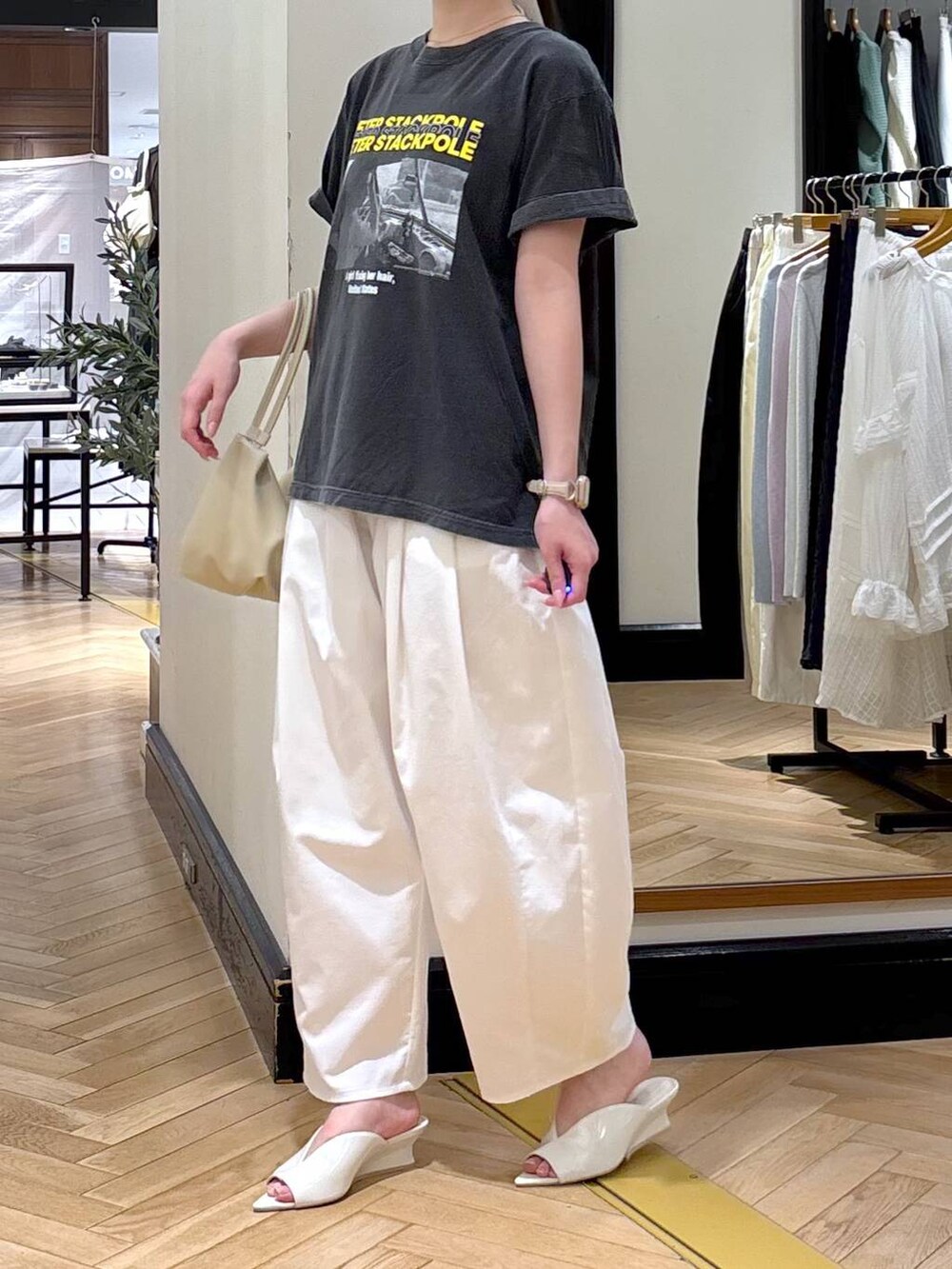ホワイト系のショルダーバッグ、グレー系のTシャツ/カットソー、ホワイト系のサンダルを着用したレディースの春コーディネートの3枚目の写真