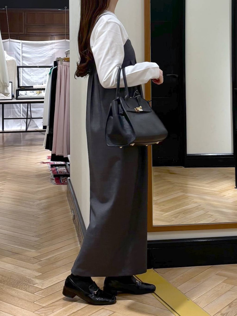 ブラック系のローファー、ブラック系のショルダーバッグ、グレー系のワンピースを着用したレディースの春コーディネートの2枚目の写真