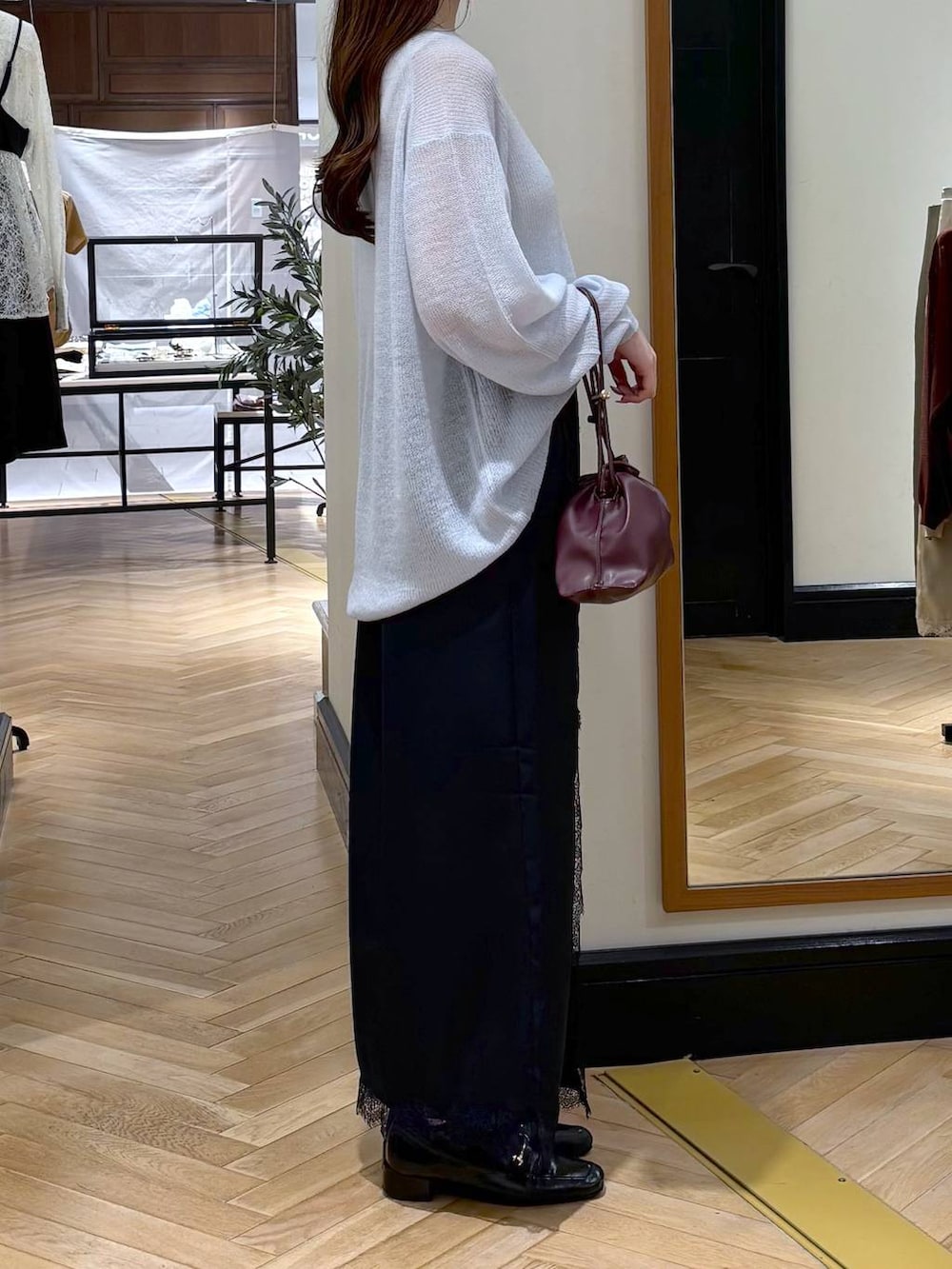 レッド系のショルダーバッグ、ブルー系のスカート、ブラック系のローファーを着用したレディースの夏コーディネートの2枚目の写真