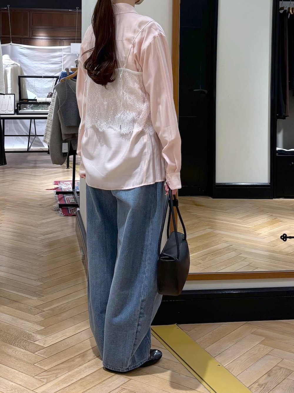 ブルー系のデニムパンツ、ブラック系のショルダーバッグ、ピンク系のシャツ/ブラウスを着用したレディースの冬コーディネートの3枚目の写真