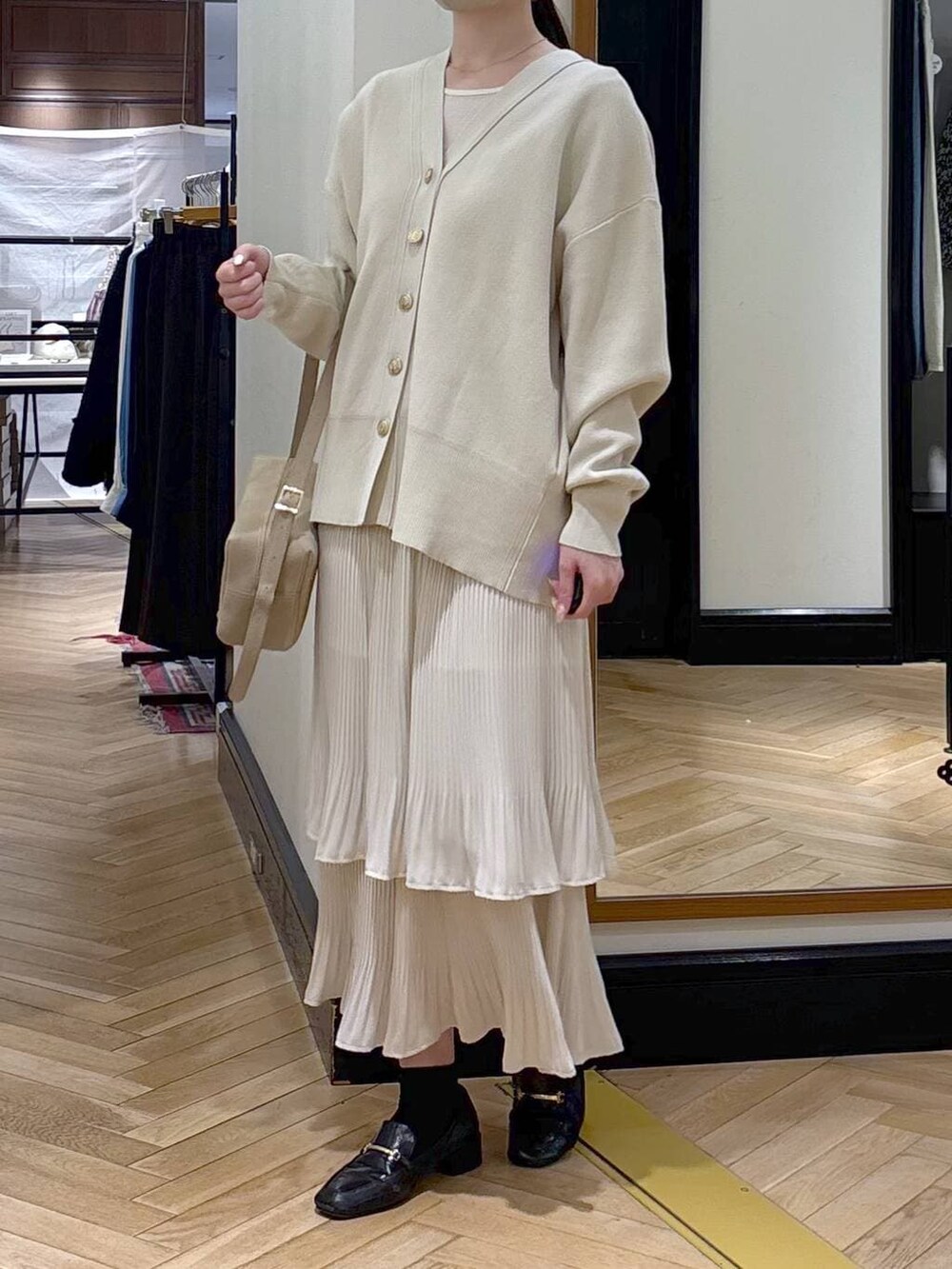 ホワイト系のスカート、ブラック系のローファー、ホワイト系のカーディガン/ボレロを着用したレディースの冬コーディネートの2枚目の写真