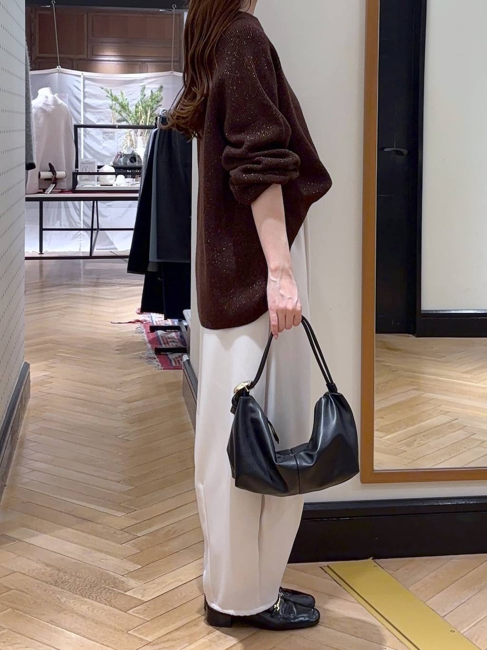 ブラック系のローファー、ブラウン系のニット/セーター、ブラック系のショルダーバッグを着用したレディースの冬コーディネートの3枚目の写真