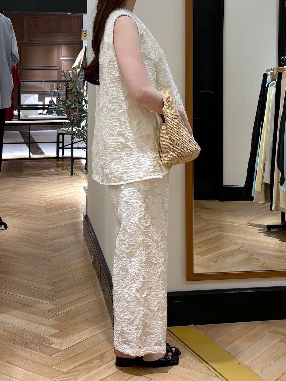 ブラック系のパンプス、ホワイト系のチュニック、ホワイト系のその他パンツを着用したレディースの春コーディネートの2枚目の写真