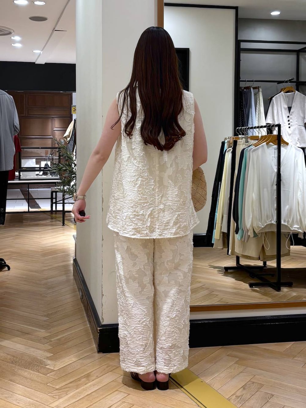 ブラック系のパンプス、ホワイト系のチュニック、ホワイト系のその他パンツを着用したレディースの春コーディネートの4枚目の写真