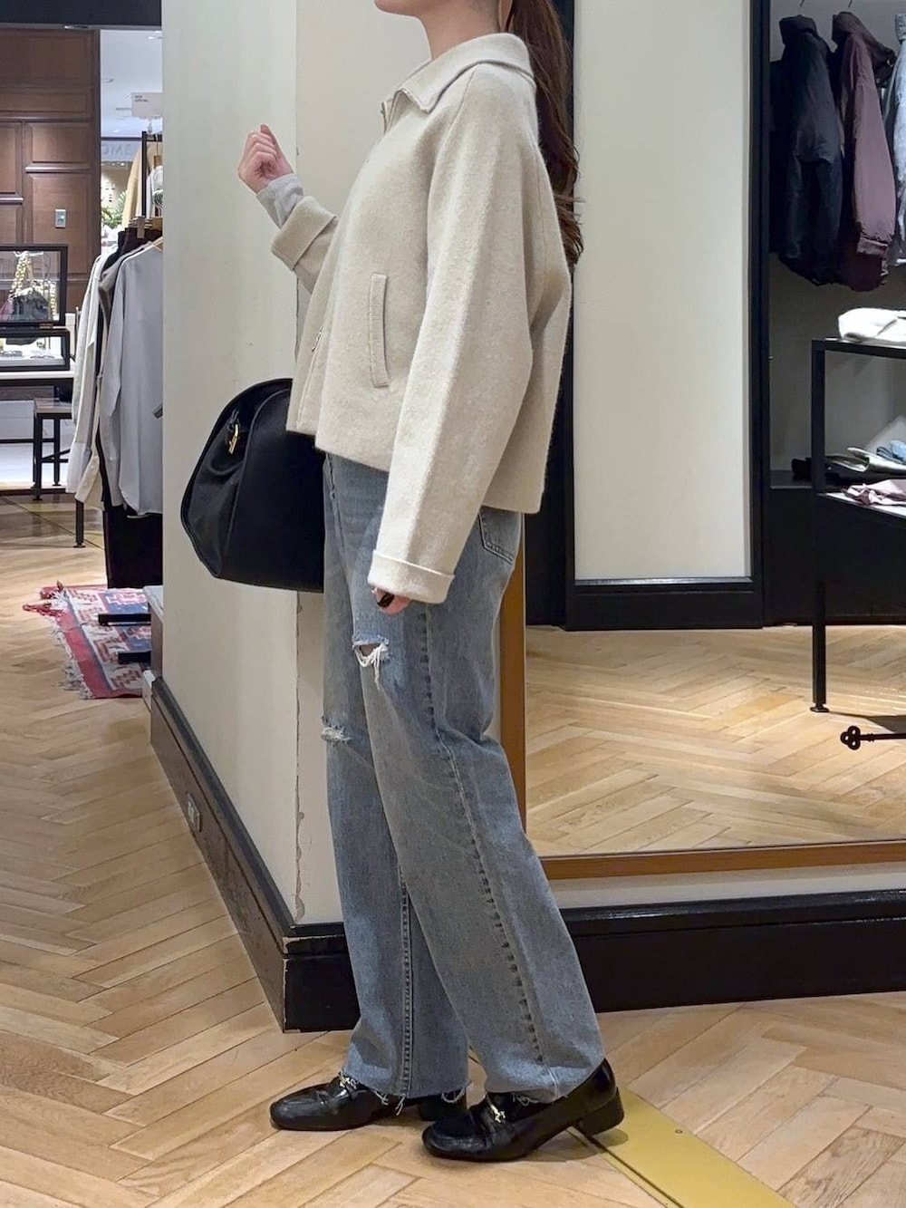 グレー系のTシャツ/カットソー、ブラック系のローファー、ブルー系のデニムパンツを着用したレディースの秋コーディネートの3枚目の写真