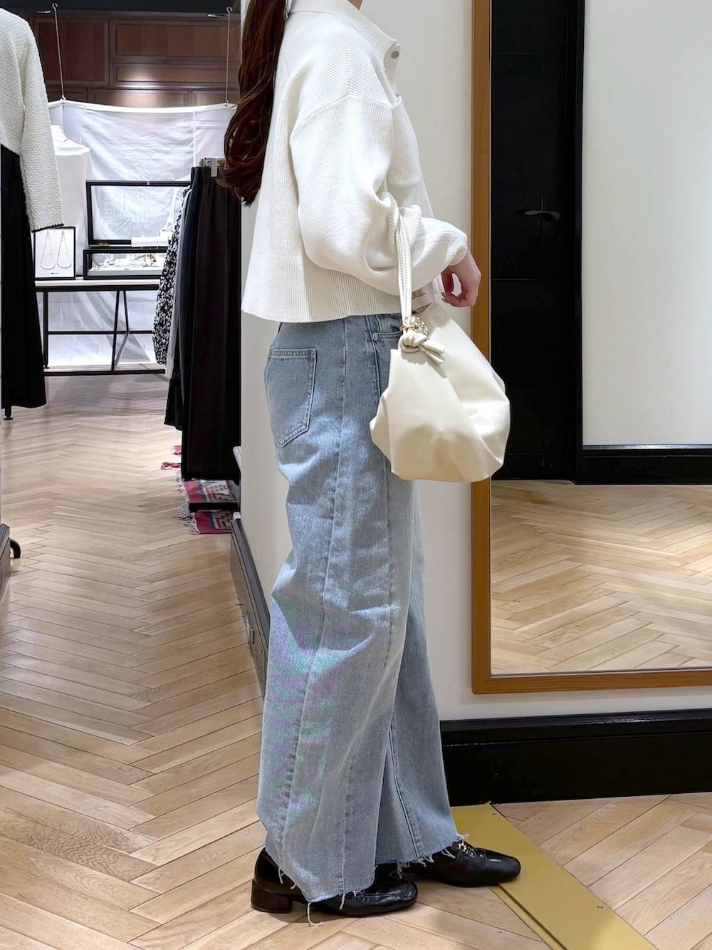 ブラック系のローファー、ブルー系のデニムパンツ、ホワイト系のカーディガン/ボレロを着用したレディースの冬コーディネートの3枚目の写真