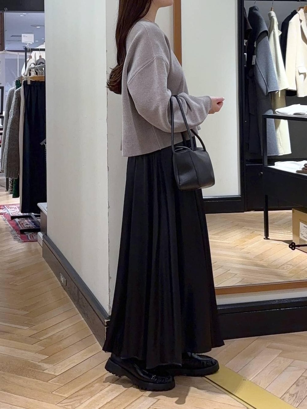 ベージュ系のニット/セーター、ブラック系のローファー、ブラック系のスカートを着用したレディースの冬コーディネートの2枚目の写真