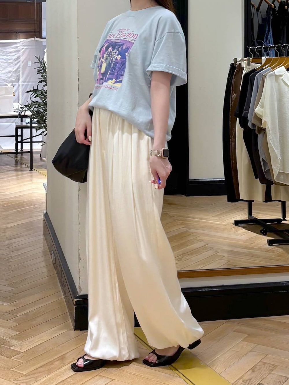 ブラック系のショルダーバッグ、ブルー系のTシャツ/カットソー、ブラック系のパンプスを着用したレディースの夏コーディネートの3枚目の写真