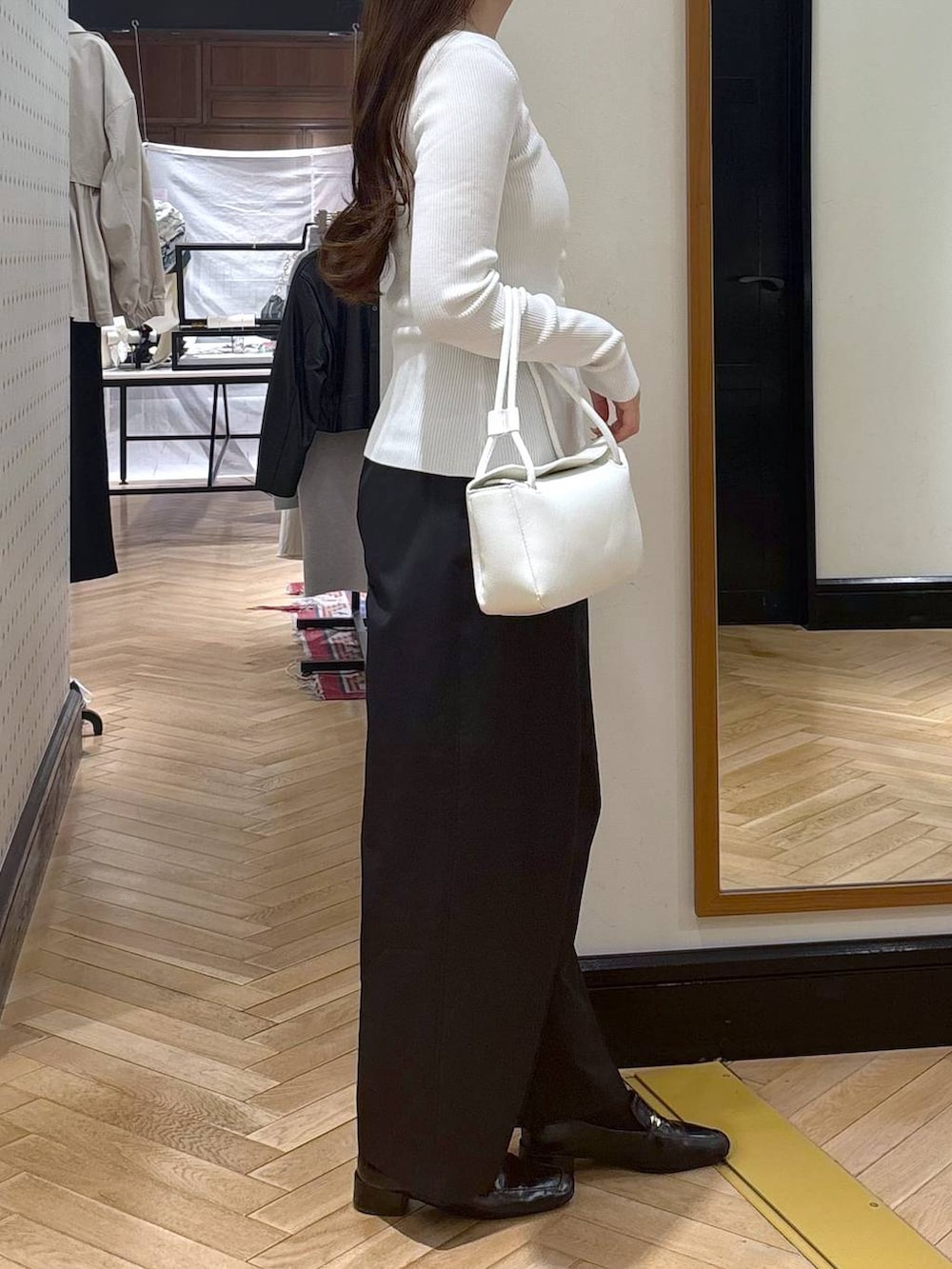ブラック系のローファー、ホワイト系のカーディガン/ボレロ、ホワイト系のショルダーバッグを着用したレディースの春コーディネートの2枚目の写真